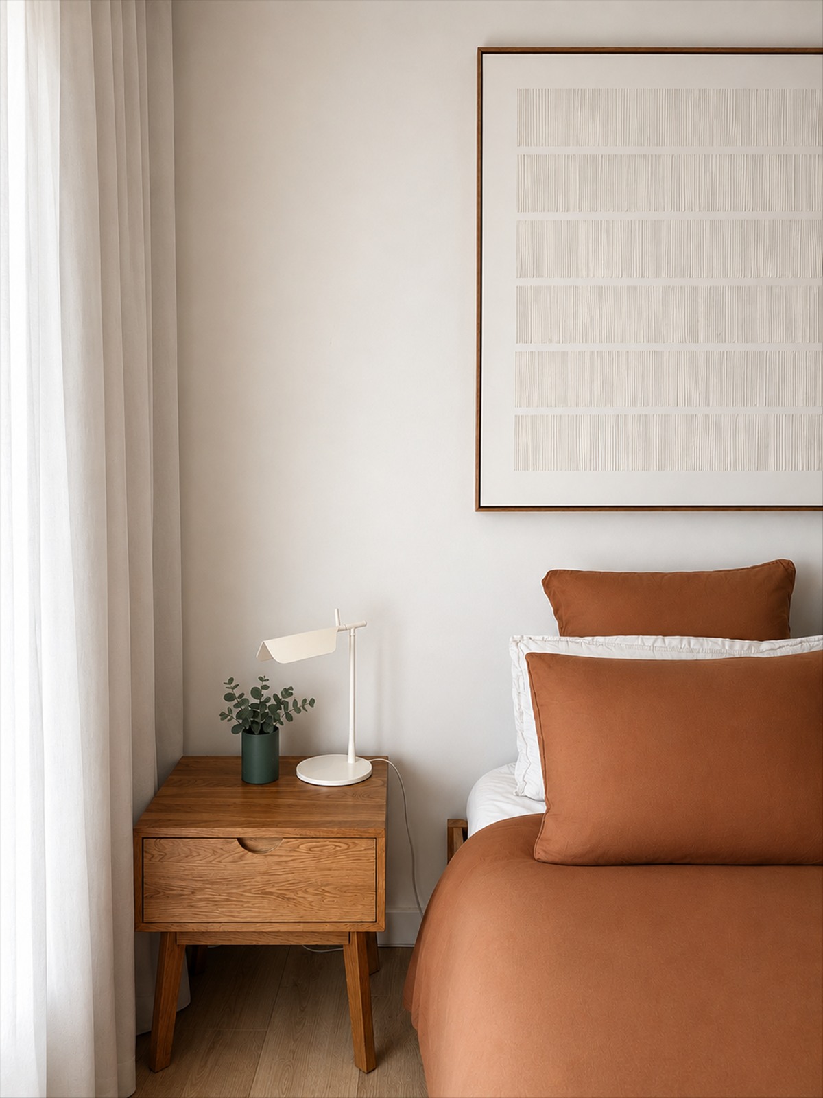 Styled bedroom with terracotta bedding, walnut nightstand and textured artwork — CKH Interiors