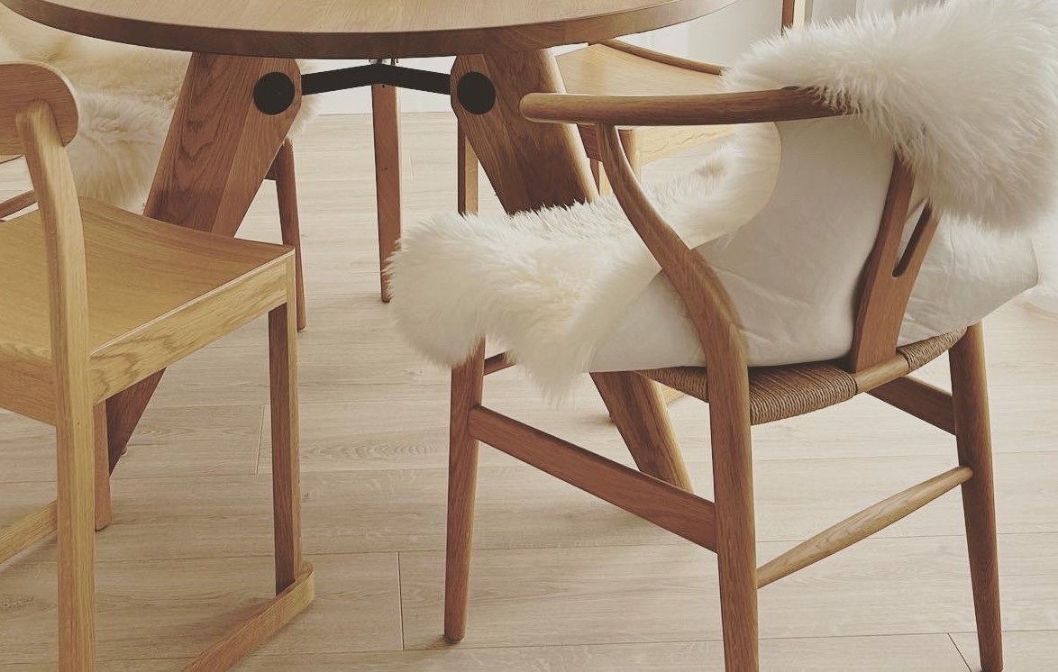 Round oak dining table with wishbone chairs and sheepskin throws — CKH Interiors